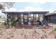 Home's backyard featuring glass enclosed patio, mulched flower beds, and large trees at 3447 Sw 19Th Pl, Ocala, FL 34474