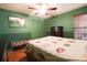 This bedroom features wood floors, a ceiling fan, bench and a spacious closet at 3447 Sw 19Th Pl, Ocala, FL 34474