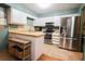 Bright kitchen featuring white cabinets, stainless steel appliances, and a breakfast bar at 3447 Sw 19Th Pl, Ocala, FL 34474