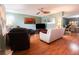 Comfortable living room with hardwood floors, a ceiling fan, and ample natural light at 3447 Sw 19Th Pl, Ocala, FL 34474