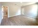 Open bedroom with wood-look tile, ensuite bathroom and doorway to additional room at 4059 Sw 131St Place Rd, Ocala, FL 34473