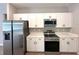 Modern kitchen featuring stainless steel appliances, white cabinets, and ample counter space for cooking at 4059 Sw 131St Place Rd, Ocala, FL 34473