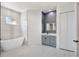 Bright bathroom with a modern tub, gray vanity, and white marble tile at 4869 Nw 101St Street Rd, Ocala, FL 34482