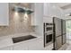 Modern kitchen with stainless steel appliances, mosaic tile backsplash, and quartz countertops at 4869 Nw 101St Street Rd, Ocala, FL 34482