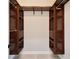 Walk-in closet with stylish dark wood shelving, cabinets, and metal hanging rods at 4869 Nw 101St Street Rd, Ocala, FL 34482