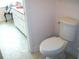 Bathroom featuring a toilet and white vanity with a pink countertop, balancing functionality with a unique design aesthetic at 5181 Sw 164Th Street Rd, Ocala, FL 34473