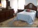 Bedroom with decorative dresser, dark wood furniture and a large rug at 5181 Sw 164Th Street Rd, Ocala, FL 34473