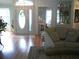 Inviting foyer with hardwood floors, a decorative flamingo glass, and a view into the living room at 5181 Sw 164Th Street Rd, Ocala, FL 34473