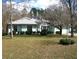 Inviting one-story home featuring a lush front lawn, mature trees, and manicured shrubbery for a serene setting at 5181 Sw 164Th Street Rd, Ocala, FL 34473
