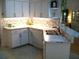 Well-lit kitchen with white cabinets, tile backsplash and modern stainless-steel sink at 5181 Sw 164Th Street Rd, Ocala, FL 34473
