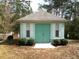 Charming outbuilding with double doors, shutters, and surrounding green shrubbery at 5181 Sw 164Th Street Rd, Ocala, FL 34473