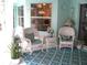 Inviting porch featuring wicker seating with blue cushions, complemented by potted plants and a patterned rug for a cozy ambiance at 5181 Sw 164Th Street Rd, Ocala, FL 34473