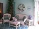 Cozy porch features wicker furniture with cushions, a decorative wreath, and potted plants creating a serene outdoor space at 5181 Sw 164Th Street Rd, Ocala, FL 34473