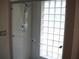 Shower with a glass door, clear glass block window, and neutral tile, offering a serene showering experience at 5181 Sw 164Th Street Rd, Ocala, FL 34473