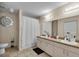 Bathroom with dual sinks, tiled floor, and a shower with a white curtain at 5758 Nw 63Rd Pl, Ocala, FL 34482