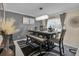 Modern dining room with elegant chandelier, stylish table setting, and chic gray accents at 5758 Nw 63Rd Pl, Ocala, FL 34482
