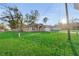 Landscaped single-story home with a spacious, well-manicured front lawn and long driveway at 5758 Nw 63Rd Pl, Ocala, FL 34482