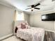 Bright bedroom features a ceiling fan, a black flatscreen, and a bed with decorative pillows at 634 Nw 56Th Ave, Ocala, FL 34482