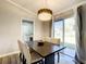 Dining room features modern chandelier, dark dining table, 4 chairs, and access to back patio at 634 Nw 56Th Ave, Ocala, FL 34482