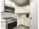Well-lit modern kitchen features white cabinetry, subway tile backsplash, stainless steel appliances, and hardwood floors at 634 Nw 56Th Ave, Ocala, FL 34482