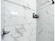 Close-up of shower with marble style tiling and shelf for bathing supplies in this bathroom at 634 Nw 56Th Ave, Ocala, FL 34482