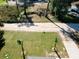 View of the front yard featuring palm trees, grass, and a sandy road nearby at 634 Nw 56Th Ave, Ocala, FL 34482