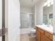Well-lit bathroom featuring a shower-tub combo with sliding glass doors and wood vanity at 7092 Sw 93Rd Ave # 1, Ocala, FL 34481