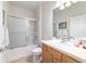 Well-lit bathroom featuring a shower-tub combo with sliding glass doors and wood vanity at 7092 Sw 93Rd Ave, Ocala, FL 34481