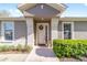 Inviting front entrance with decorative wreath, manicured bushes, and pot of flowers at 7092 Sw 93Rd Ave # 1, Ocala, FL 34481