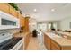 Bright kitchen featuring warm wood cabinetry, a breakfast bar, and views of the dining area at 7092 Sw 93Rd Ave # 1, Ocala, FL 34481