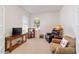 Cozy living room features neutral carpet, furniture, a TV console, and multiple windows with blinds for natural light at 7092 Sw 93Rd Ave # 1, Ocala, FL 34481