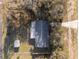 Overhead view of home with well-kept lawn, detached storage shed, and mature trees at 7280 Se County Highway 25A, Belleview, FL 34420