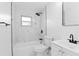 Bathroom featuring new fixtures, tub with shower, and white marble-like tiling at 7280 Se County Highway 25A, Belleview, FL 34420