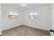Bedroom with two large windows, neutral paint and light gray wood look flooring at 7280 Se County Highway 25A, Belleview, FL 34420