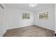 Well-lit bedroom with two windows, new wood-look flooring and neutral paint at 7280 Se County Highway 25A, Belleview, FL 34420
