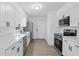 Bright kitchen featuring white cabinets, stainless steel appliances, and gray wood-look flooring at 7280 Se County Highway 25A, Belleview, FL 34420