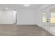 Bright living room featuring sleek, light wood-look flooring and French doors to the backyard at 7280 Se County Highway 25A, Belleview, FL 34420