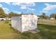 White exterior shed with simple design and concrete foundation in grassy backyard at 7280 Se County Highway 25A, Belleview, FL 34420