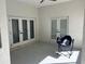 Private patio with white walls and a chair features two sets of French doors at 7550 Sw 185 Cir, Dunnellon, FL 34432