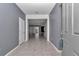 A neutral foyer with a gray door, tiled floor, and an open view into the rest of the house at 8371 Sw 59Th Ter, Ocala, FL 34476