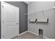 Well-organized laundry room with gray accent wall, shelving, and tile floors at 8371 Sw 59Th Ter, Ocala, FL 34476