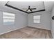 Spacious bedroom with carpet floors, a tray ceiling, and multiple windows for natural light at 8371 Sw 59Th Ter, Ocala, FL 34476