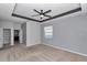 Bedroom with carpet, a tray ceiling, and adjoining bathroom and closet entries at 8371 Sw 59Th Ter, Ocala, FL 34476
