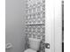 Stylish powder room with geometric patterned wallpaper and floating shelves for added storage at 8371 Sw 59Th Ter, Ocala, FL 34476