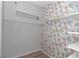 Spacious walk-in closet with floral wallpaper, providing ample storage space and organization at 8371 Sw 59Th Ter, Ocala, FL 34476