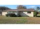 Rear exterior view of home, showing the enclosed porch, lush landscaping, and well-maintained yard at 8516 Sw 105Th Pl, Ocala, FL 34481
