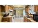 Functional kitchen with wooden cabinets, tile floors, standard appliances, and a view of the breakfast area at 8516 Sw 105Th Pl, Ocala, FL 34481