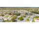 An aerial view shows a residential neighborhood with mature trees and a scenic pond at 8961 Se 130Th Loop, Summerfield, FL 34491