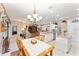 Open concept kitchen and living room features white cabinets, and a wooden dining set at 8961 Se 130Th Loop, Summerfield, FL 34491