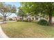Beautifully landscaped front yard featuring lush green grass and mature trees at 8961 Se 130Th Loop, Summerfield, FL 34491